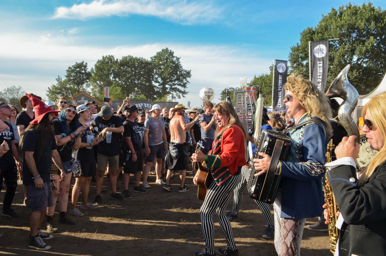 Gluthitze in Wacken - Schlammschlacht? Ja, aber nur bei lecker Wasserleitung. – Stimmung auf der Meile mit Blaas of Glory.