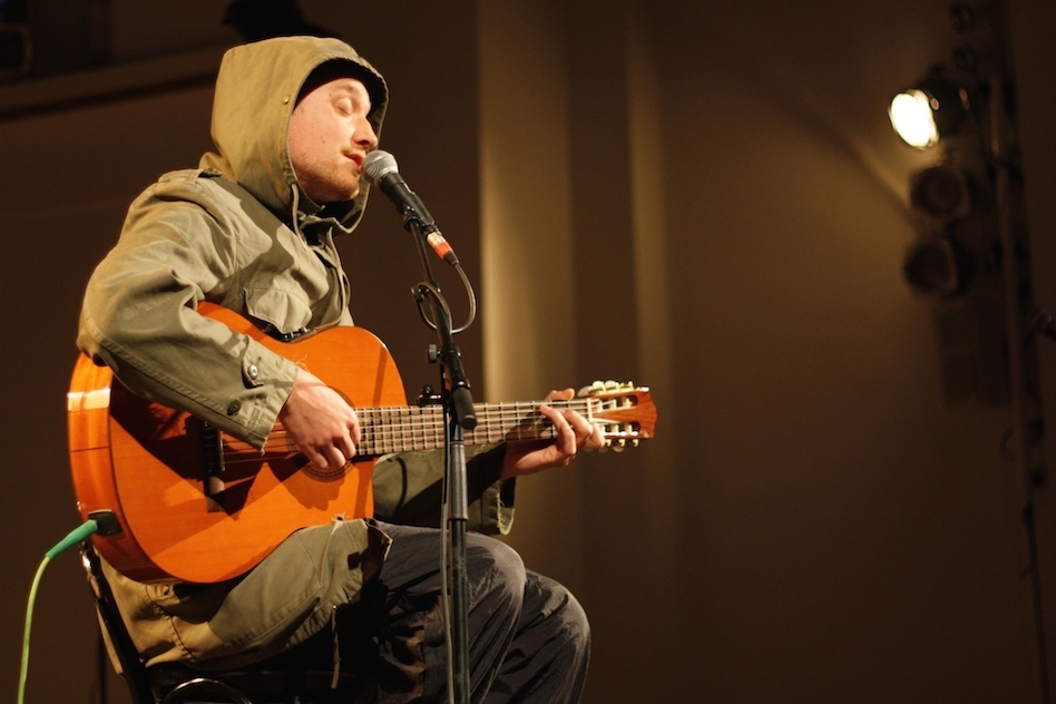 Ein Rapper singt und spielt Gitarre. – Maeckes.